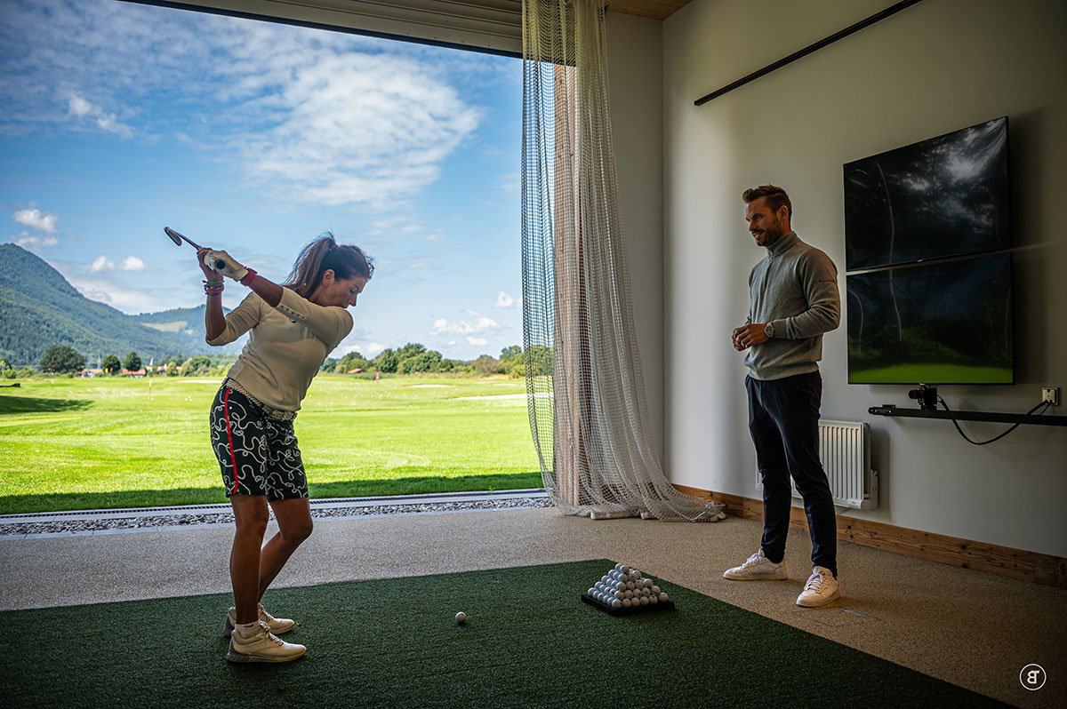Frau spielt Golf, Simon Hangel beobachtet.